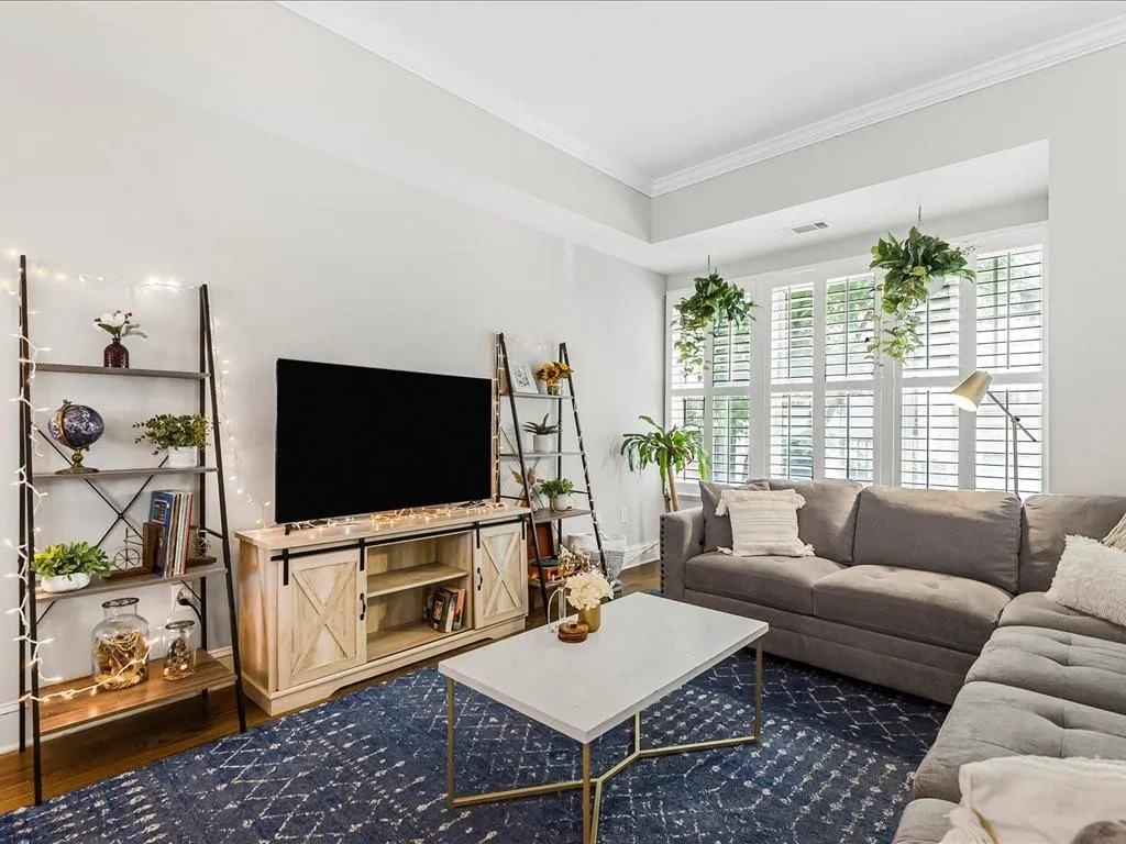 Living area with wood finished floors and ornamental molding