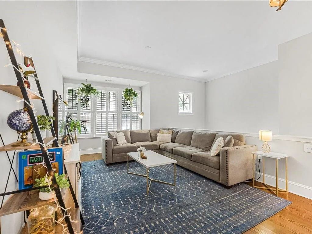 Living area featuring wood finished floors and crown molding