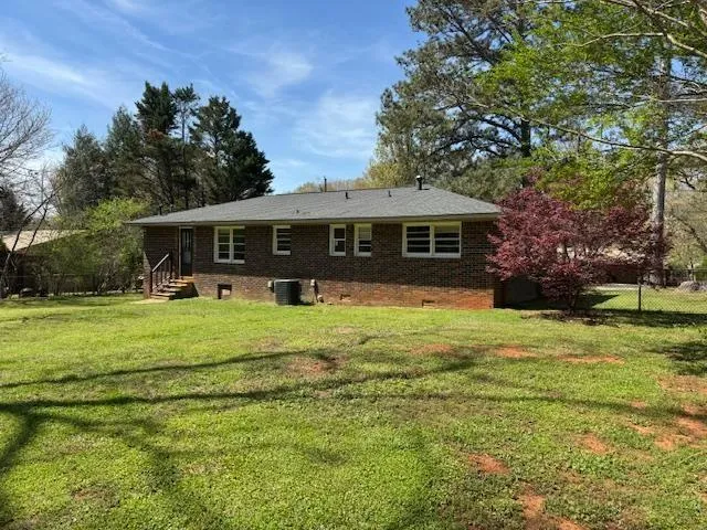Back of property featuring brick siding and crawl space