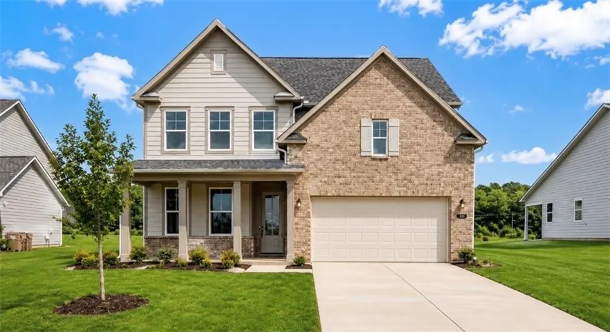 Two-story exterior with brick and siding facade, covered front porch, attached garage, and concrete driveway