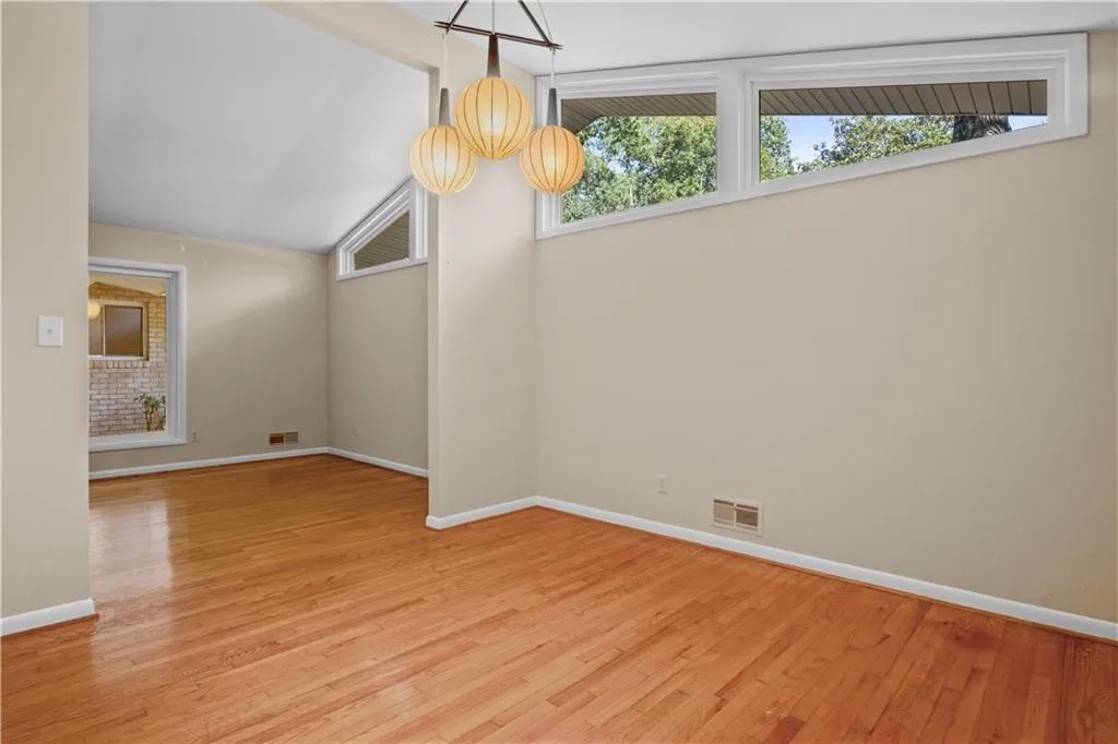 Unfurnished dining area with lofted ceiling, a healthy amount of sunlight, and light hardwood / wood-style floors Unfurnished dining area with lofted ceiling, a healthy amount of sunlight, and light hardwood / wood-style floors