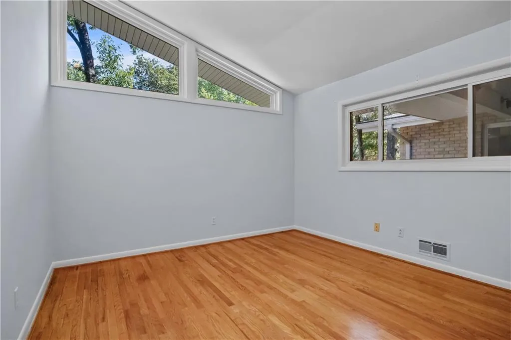 Empty room with light wood-type flooring, vaulted ceiling, and a healthy amount of sunlight Empty room with light wood-type flooring, vaulted ceiling, and a healthy amount of sunlight