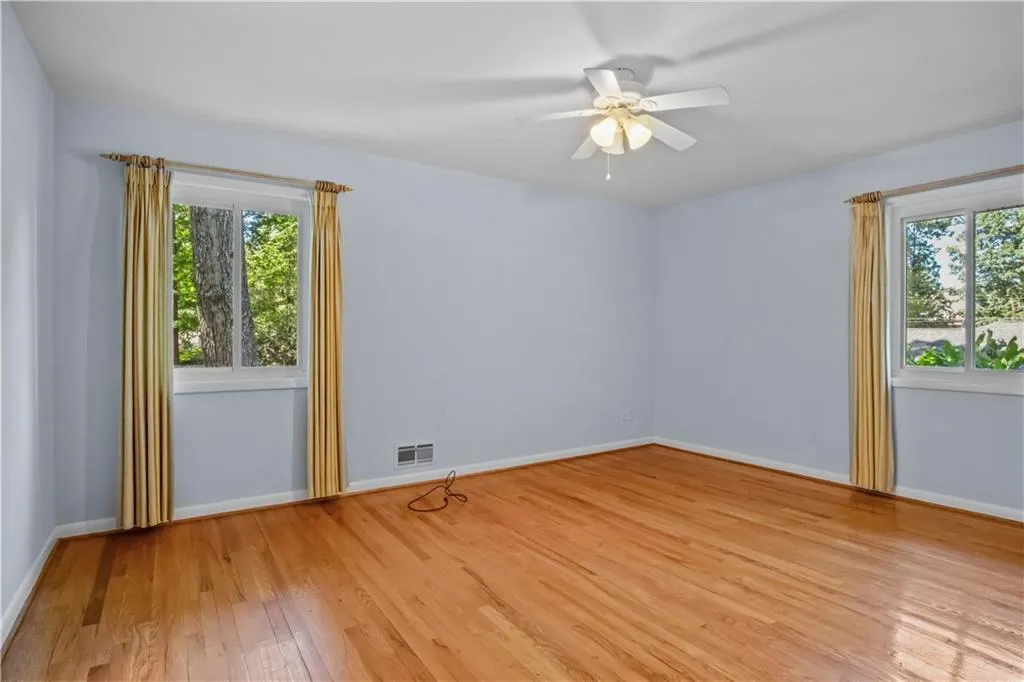 Spare room featuring ceiling fan, a wealth of natural light, and light hardwood / wood-style floors Spare room featuring ceiling fan, a wealth of natural light, and light hardwood / wood-style floors