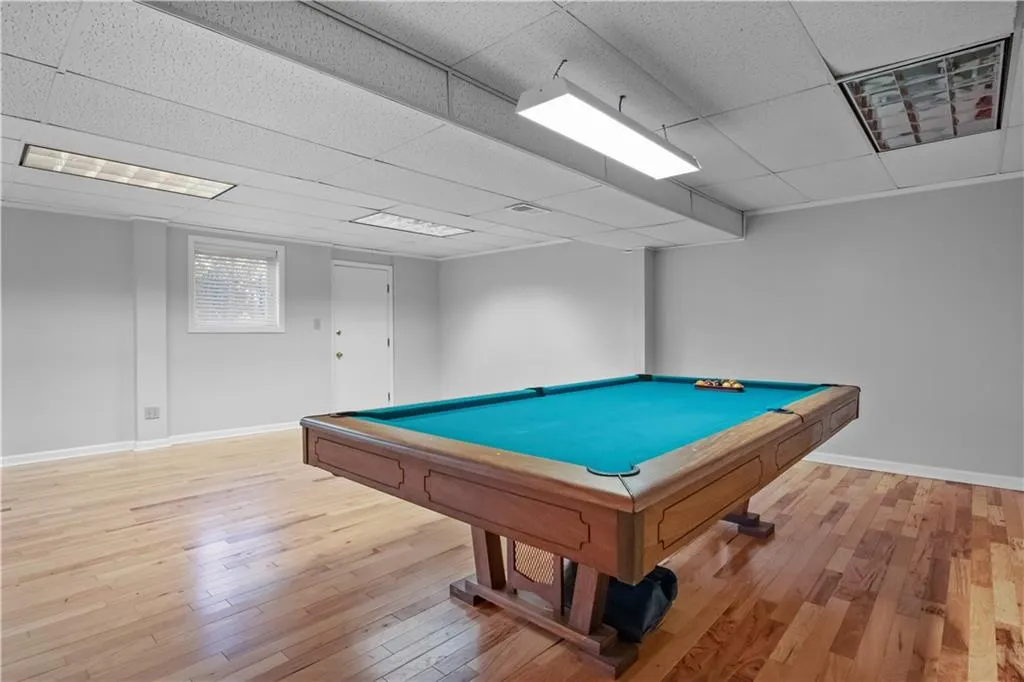 Playroom with pool table, a paneled ceiling, and hardwood / wood-style floors Playroom with pool table, a paneled ceiling, and hardwood / wood-style floors