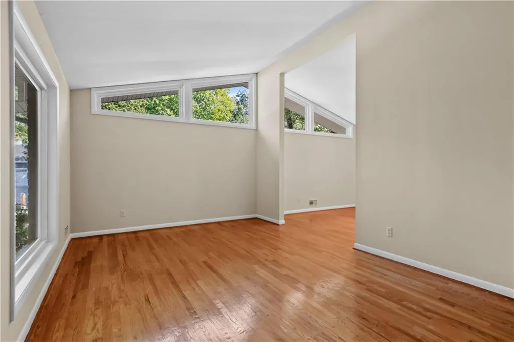 Spare room with light wood-type flooring and lofted ceiling Spare room with light wood-type flooring and lofted ceiling