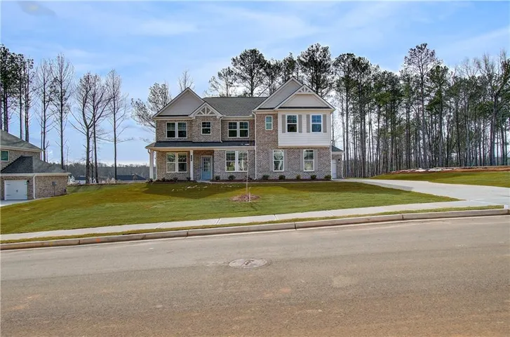 Two-story residence featuring a brick and siding facade with a gabled roofline