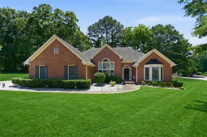 Red brick single-story residence with a dark roof and light-colored trim