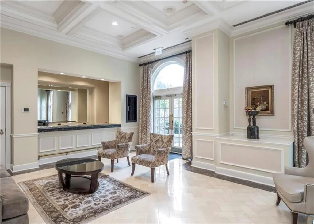 Sitting room featuring french doors, coffered ceiling, ornamental molding, beam ceiling, and a high ceiling