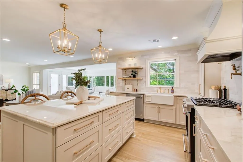 Kitchen has a farmhouse sink, pot filler, & beautiful lighting detail.
