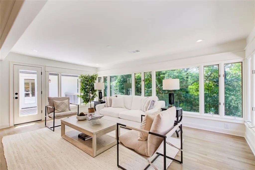 Sunroom with wall of windows leads to two decks.