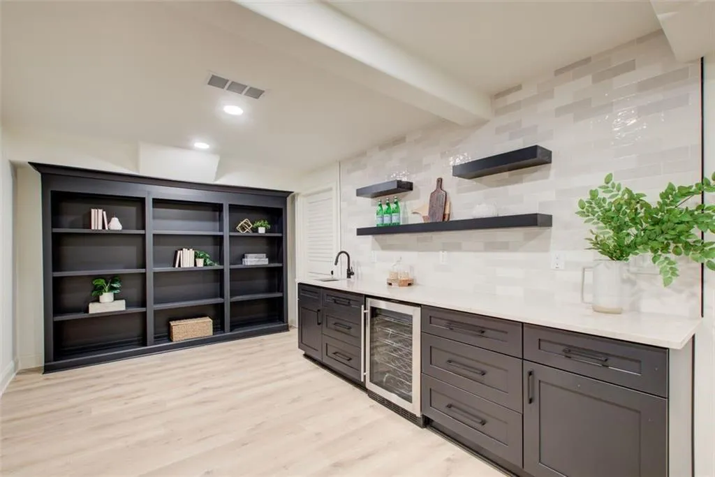 Custom wet bar with beverage fridge, quartzite counters & Zellige tile backsplash