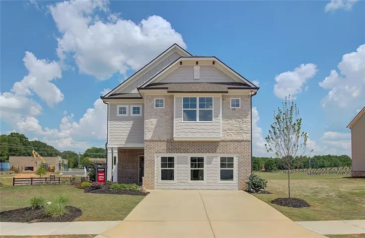 Two-story residence featuring a mixed-material facade, attached garage, and a concrete driveway