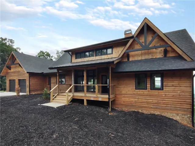Striking timber-frame exterior with decorative half-timbering and stone accents, complemented by a covered front porch and multiple gable rooflines