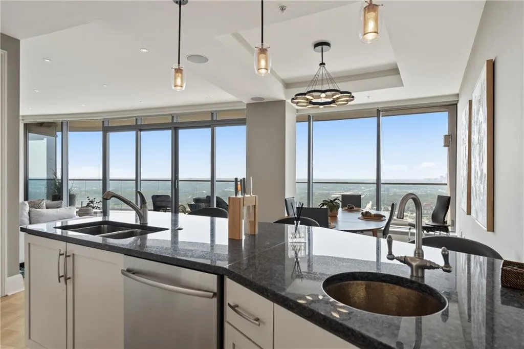 Kitchen featuring white cabinets, healthy amount of natural light, stainless steel dishwasher, floor to ceiling windows, and recessed lighting