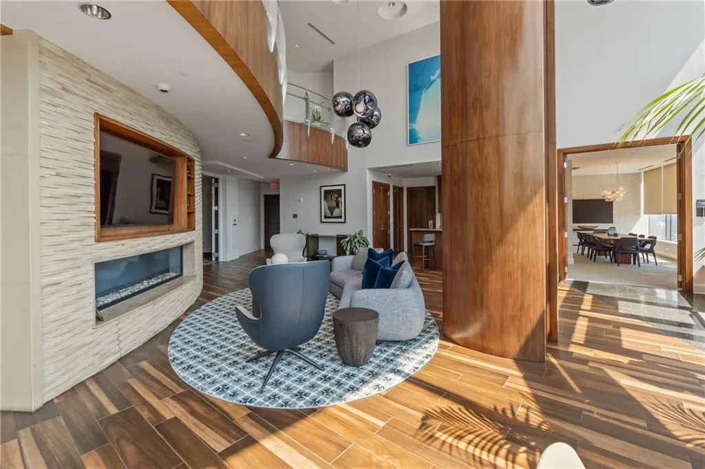 Living area with a towering ceiling, dark wood-type flooring, and a chandelier