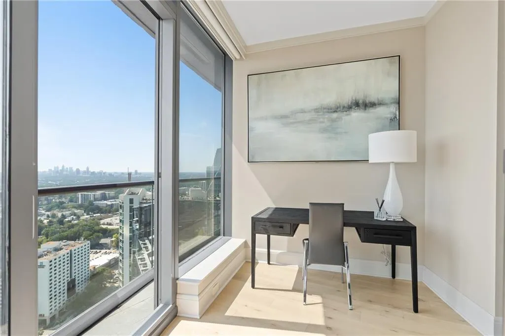 Office area with a city view, wood finished floors, and ornamental molding