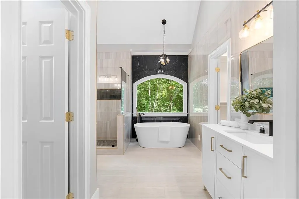 Bathroom featuring vanity, a freestanding bath, tile walls, and a stall shower