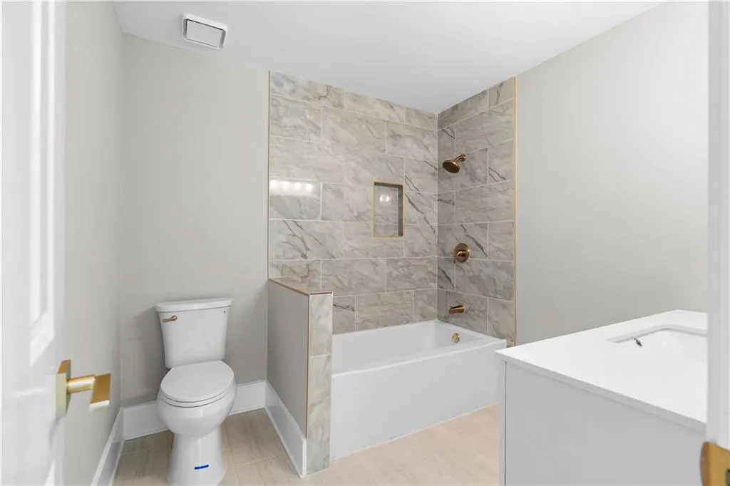 Full bath featuring vanity, bathing tub / shower combination, and wood finished floors