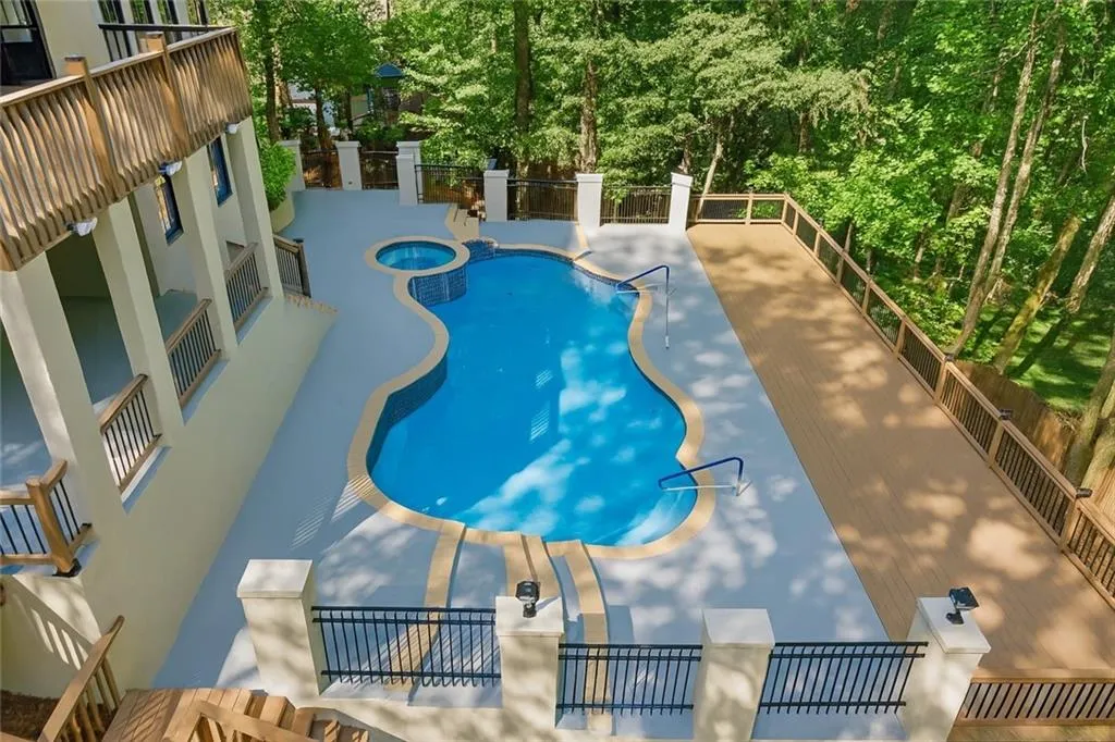View of pool featuring a pool with connected hot tub and a patio area