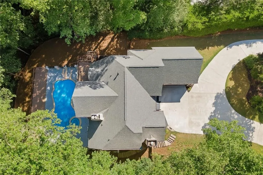 Aerial view of property and surrounding area with a large body of water and a pool