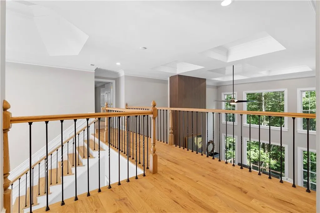 Corridor with crown molding, wood finished floors, an upstairs landing, recessed lighting, and coffered ceiling