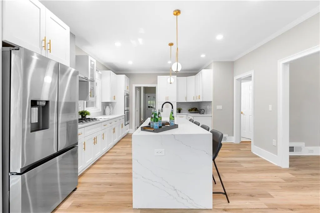 Kitchen with stainless steel appliances, light wood-style floors, white cabinets, recessed lighting, and crown molding