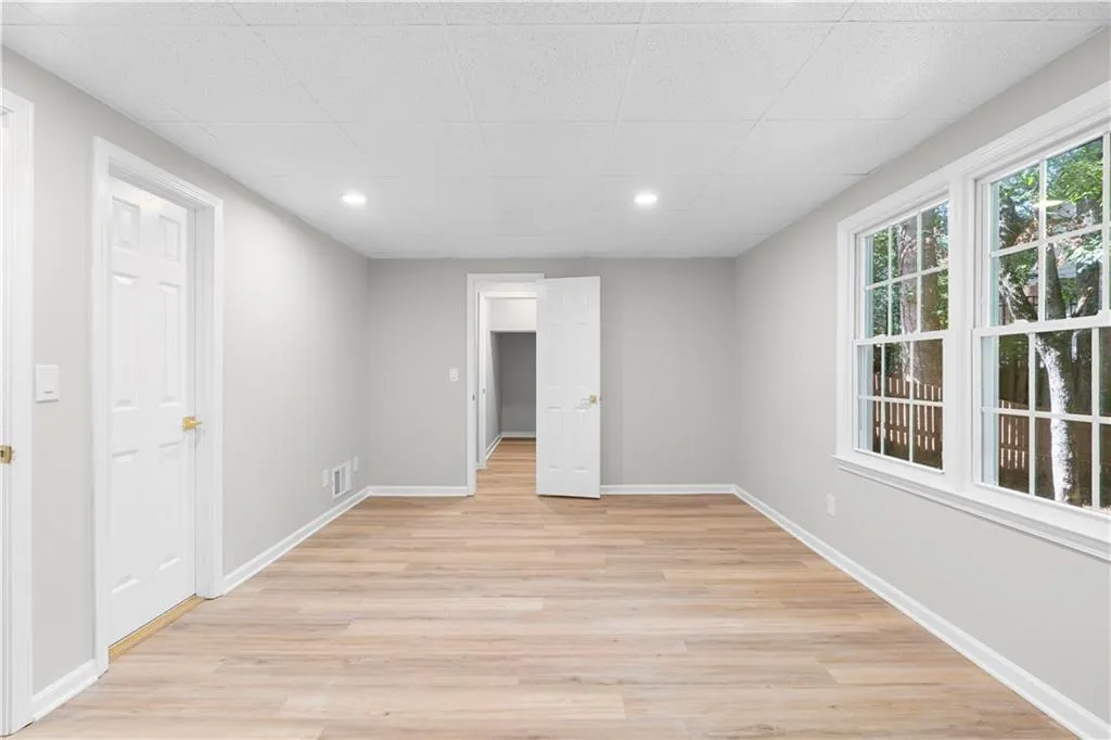 Unfurnished room featuring light wood-style flooring, recessed lighting, and a drop ceiling
