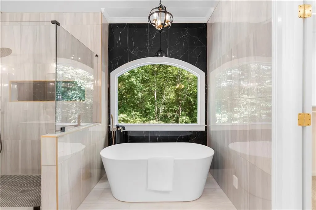 Full bathroom with tile walls, a soaking tub, a shower stall, and ornamental molding