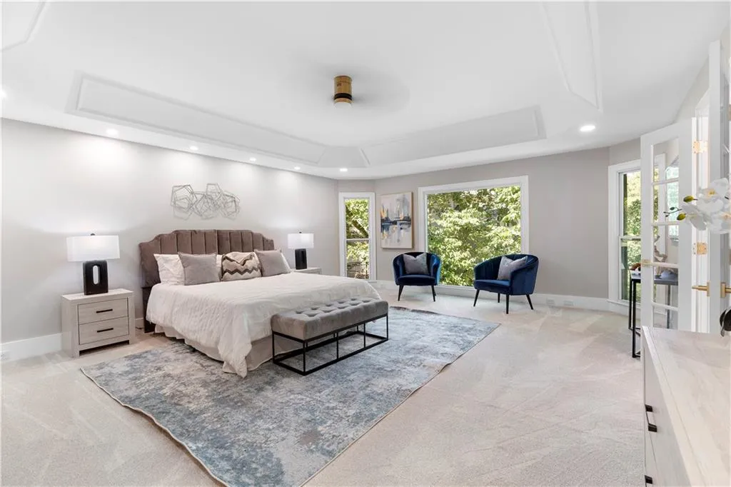 Bedroom with recessed lighting, a tray ceiling, light carpet, and attic access