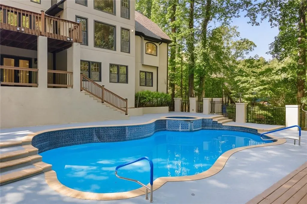 View of pool featuring stairway and a pool with connected hot tub