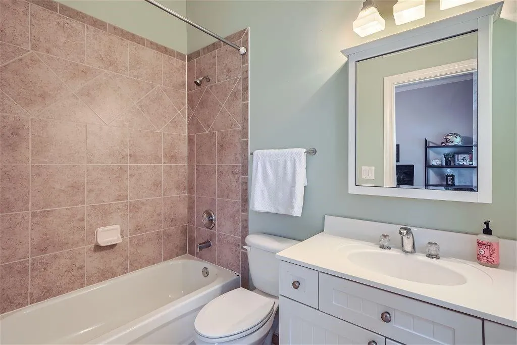 Full bathroom featuring vanity, toilet, and tiled shower / bath combo