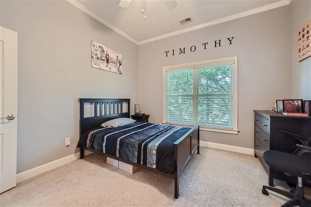 Bedroom with crown molding, ceiling fan, and light colored carpet