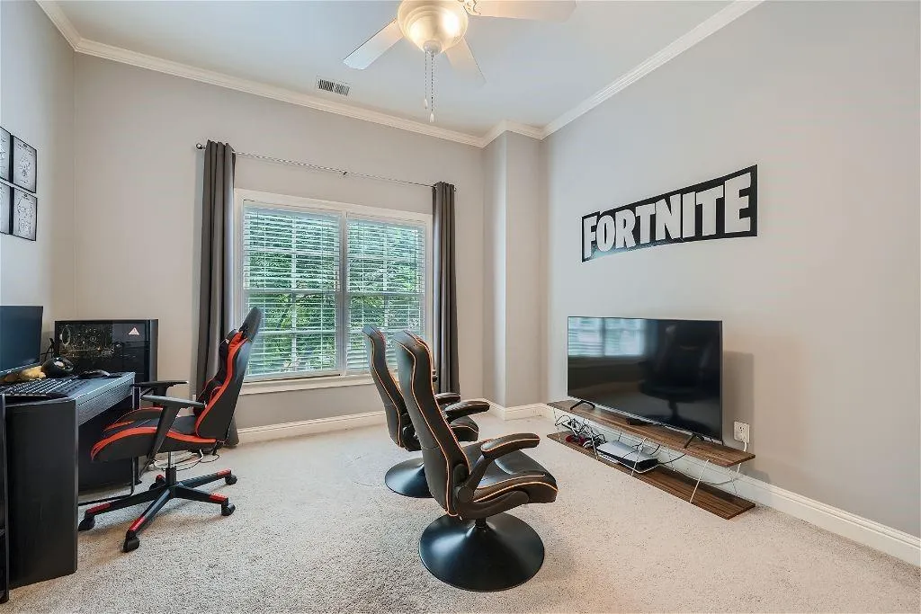 Carpeted home office featuring ornamental molding and ceiling fan