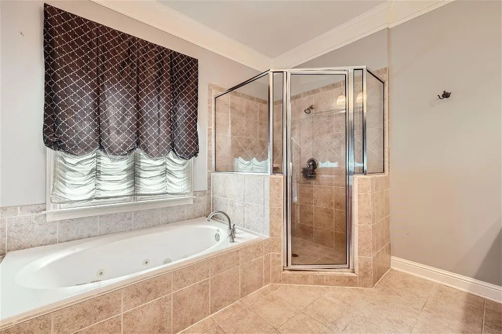 Bathroom with tile floors, ornamental molding, and shower with separate bathtub
