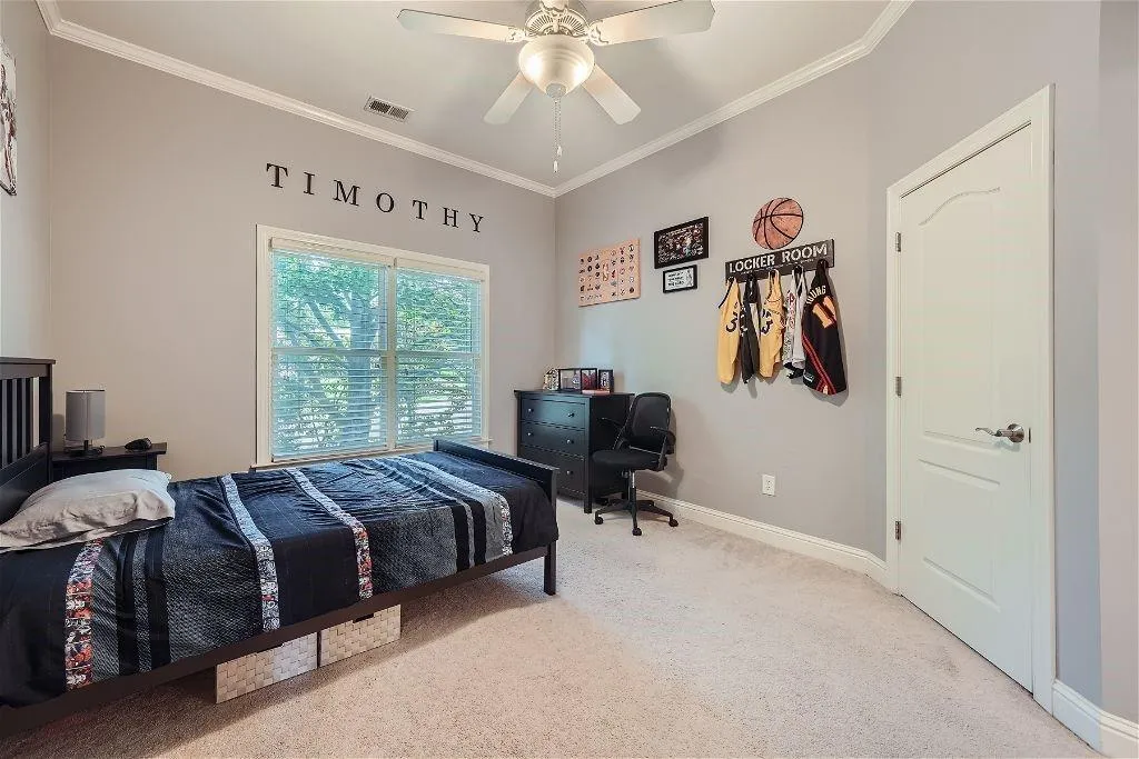 Bedroom with carpet, ceiling fan, and crown molding