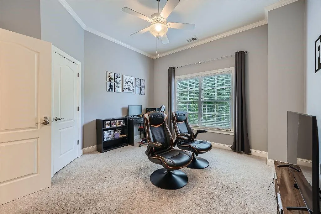 Living area featuring ceiling fan, light carpet, and ornamental molding