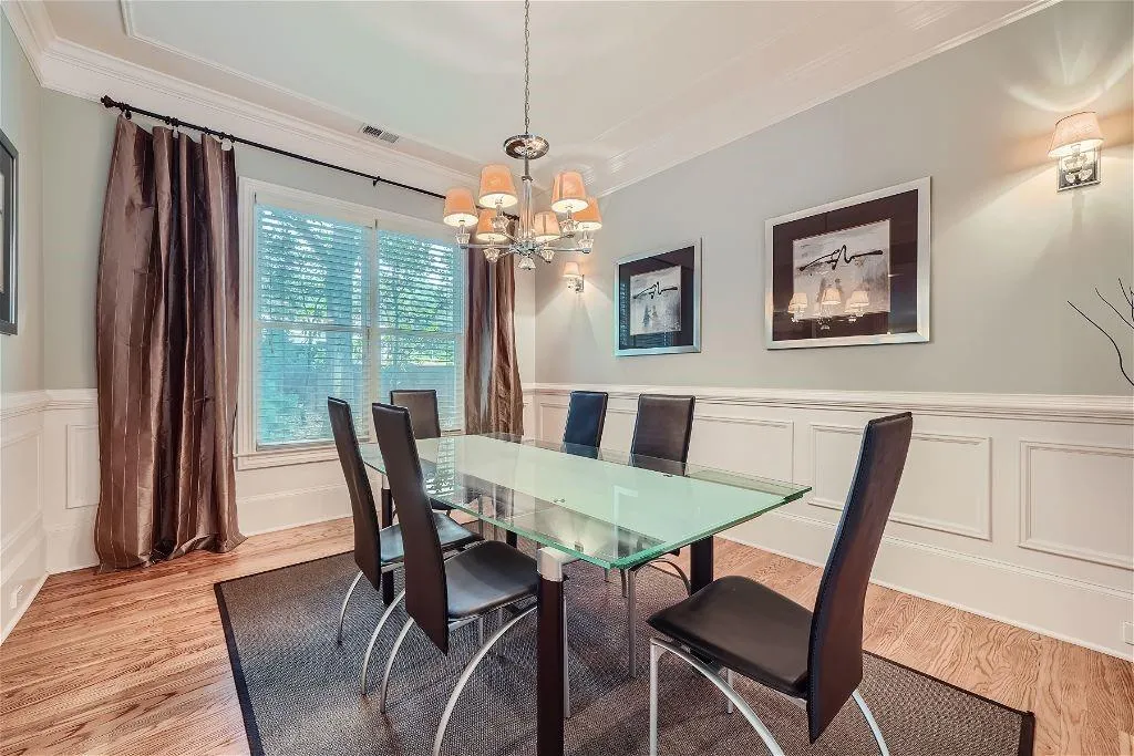 Dining area featuring an inviting chandelier, light hardwood / wood-style floors, and crown molding