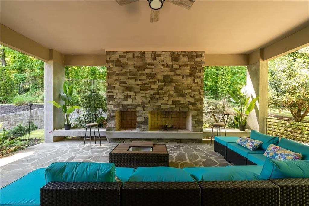 View of patio featuring an outdoor living space with a fireplace and ceiling fan