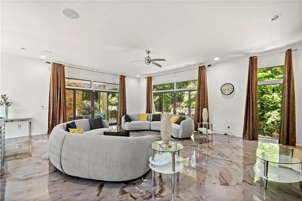 Living room featuring marble tiled flooring, ceiling fan, and recessed lighting