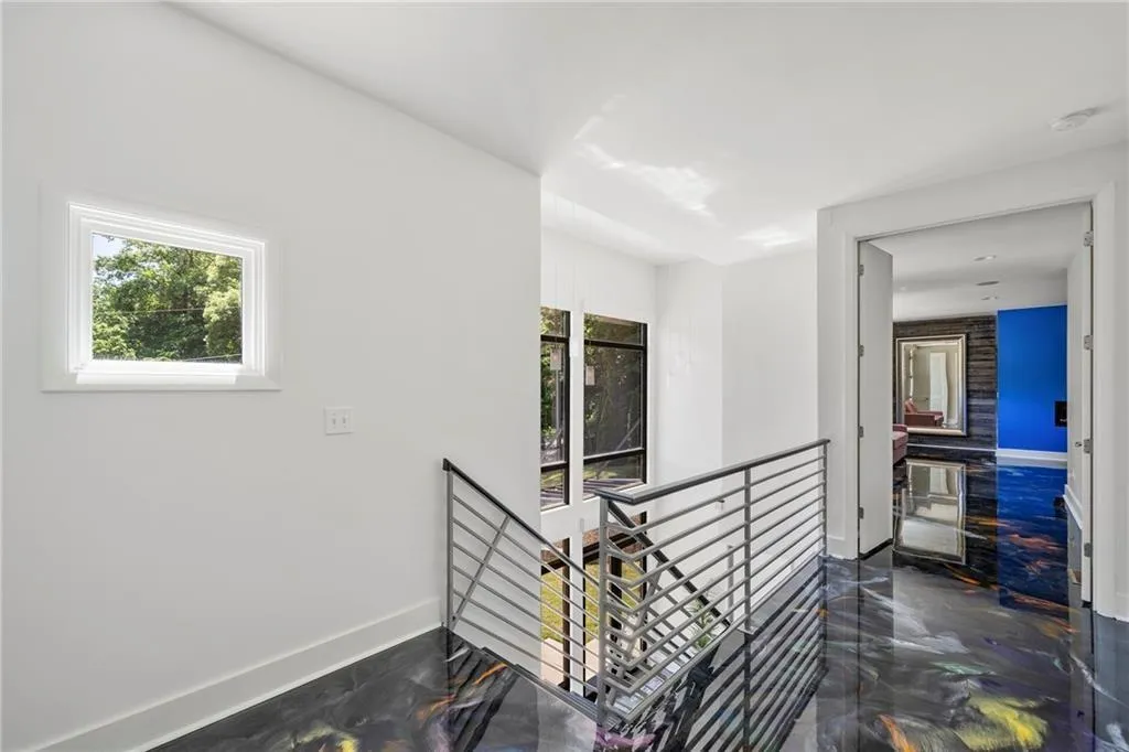 Hallway with an upstairs landing and dark marble finish floors