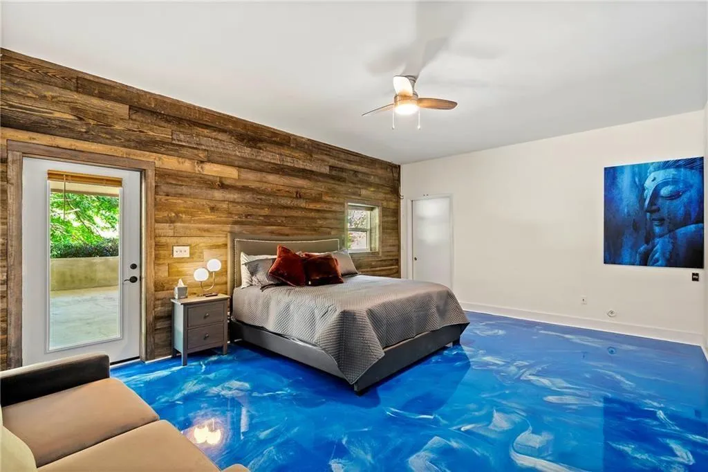 Bedroom with wooden walls, access to exterior, multiple windows, and ceiling fan
