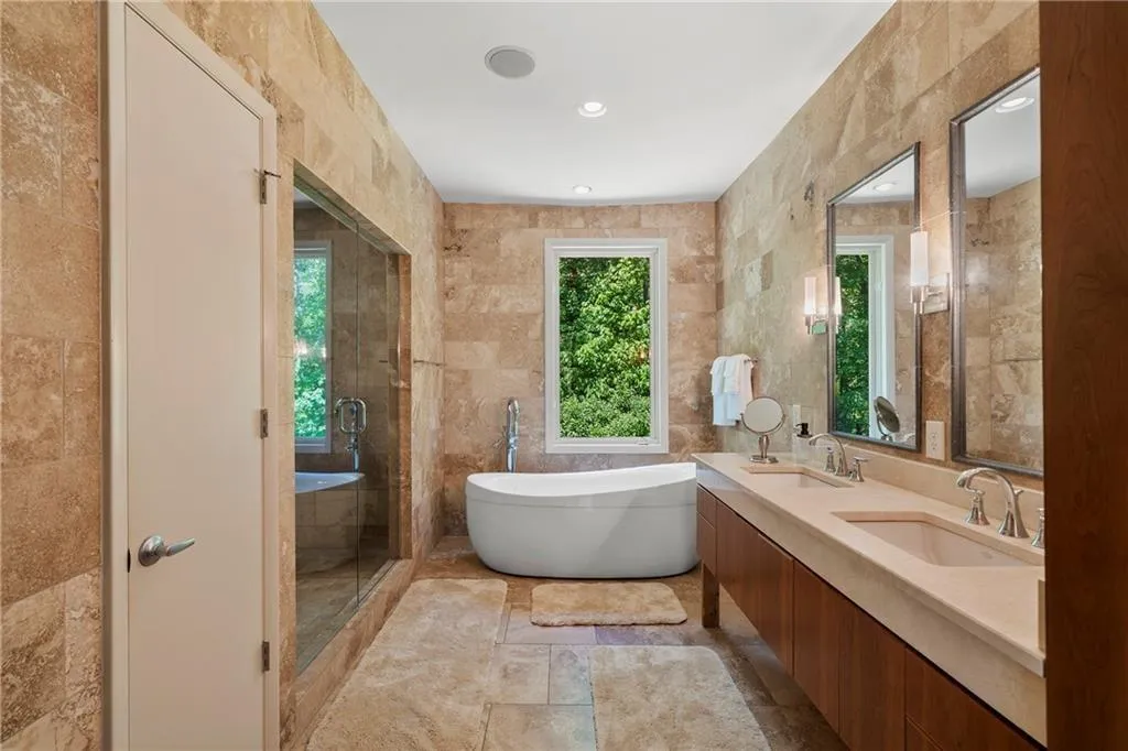 Full bathroom featuring tile walls, a soaking tub, a stall shower, double vanity, and recessed lighting