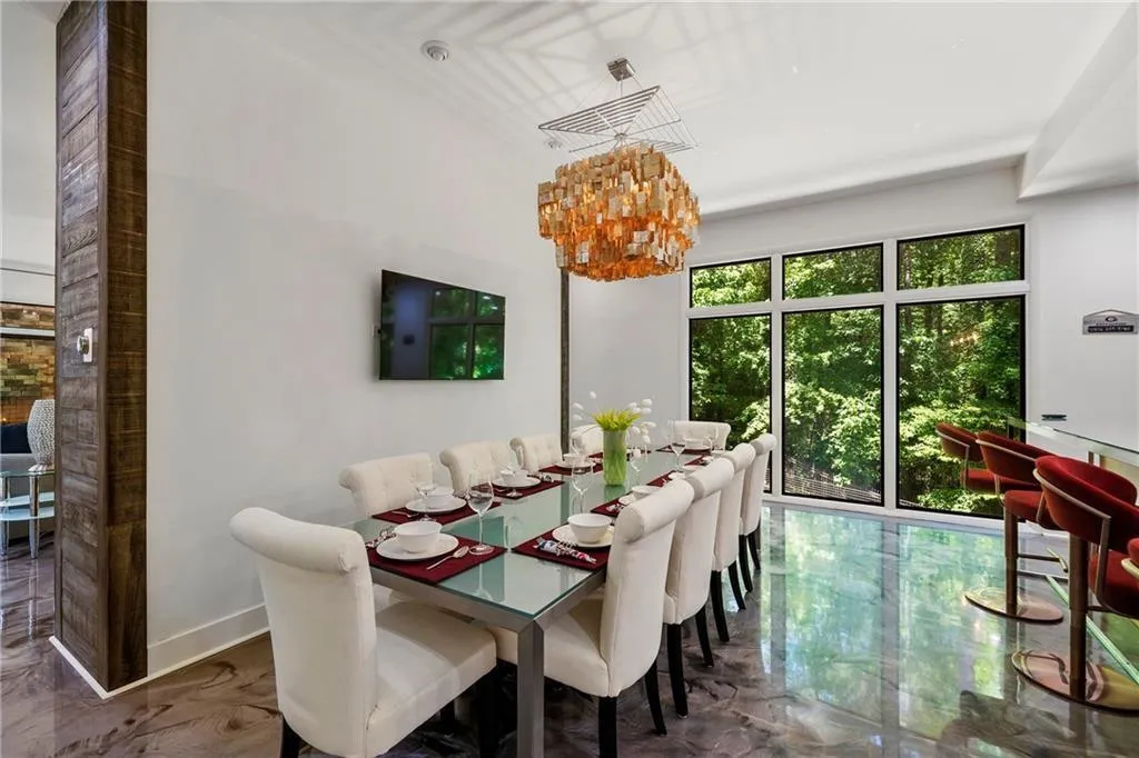 Dining area with a chandelier and dark marble finish flooring