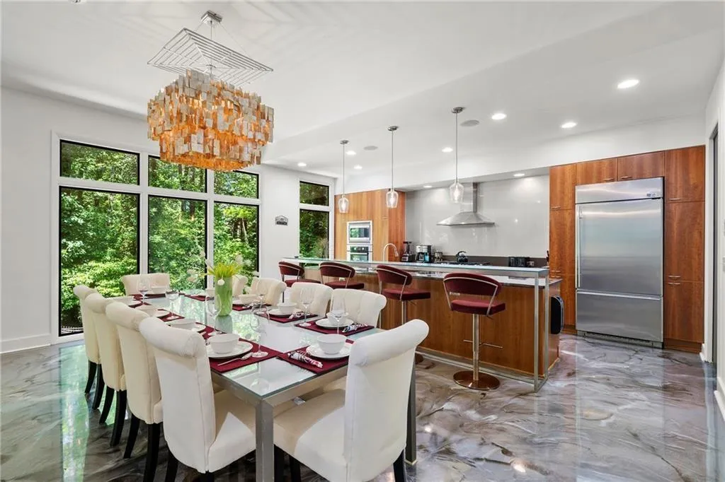 Dining space featuring light marble finish flooring, recessed lighting, and a chandelier