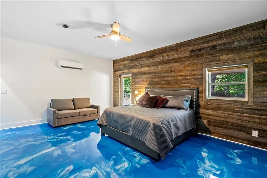 Bedroom featuring wood walls, a ceiling fan, and a wall mounted AC