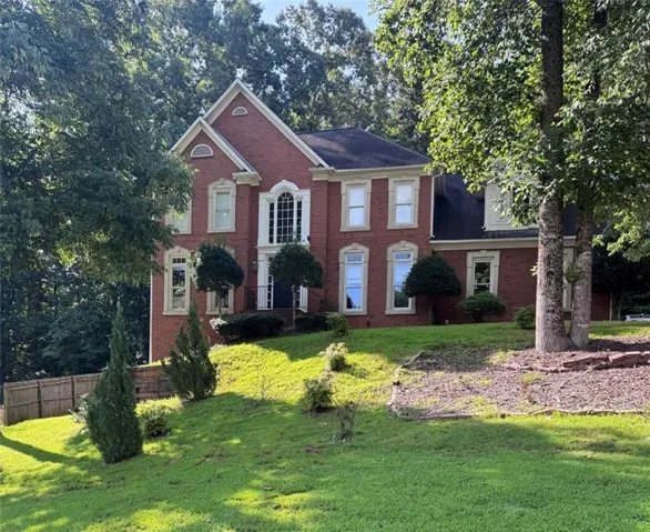 Brick exterior with a prominent arched window, multiple gabled rooflines, and decorative window surrounds