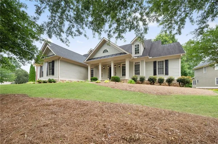Traditional-style residence featuring light-colored siding and a dark shingle roof