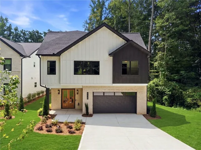 Contemporary exterior featuring a black shingle roof, white vertical siding, and dark accent siding