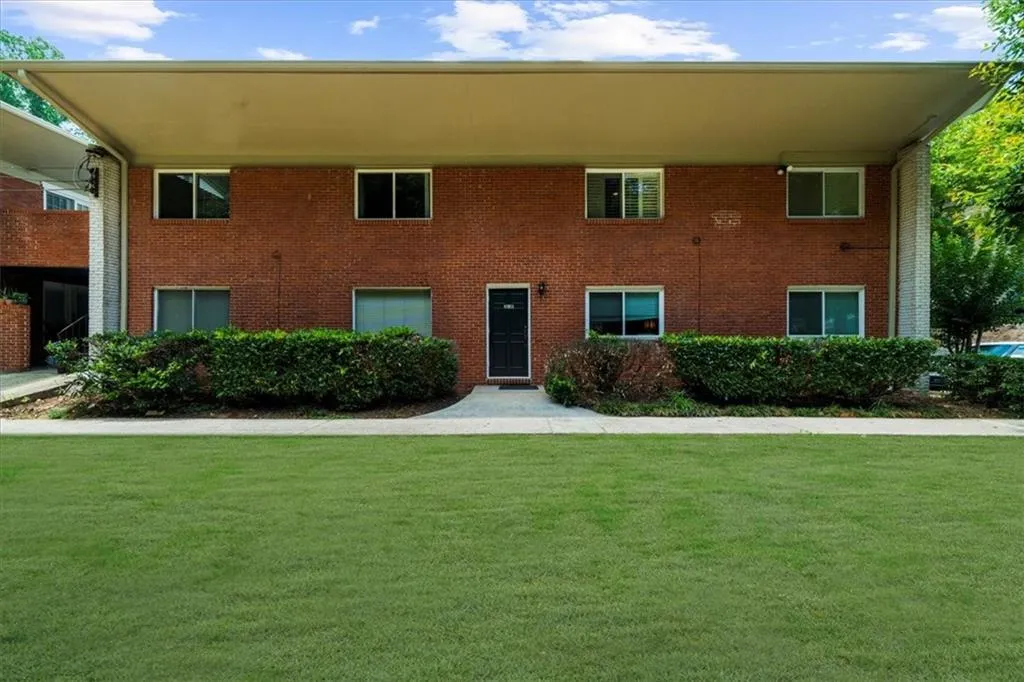 View of front of property with a front yard and brick siding