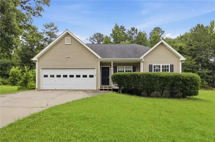 Ranch-style residence featuring a prominent front-facing garage with a paneled door